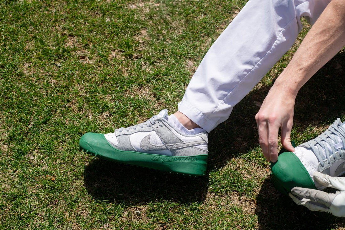 Golfer putting MyMullies over sneakers before teeing off