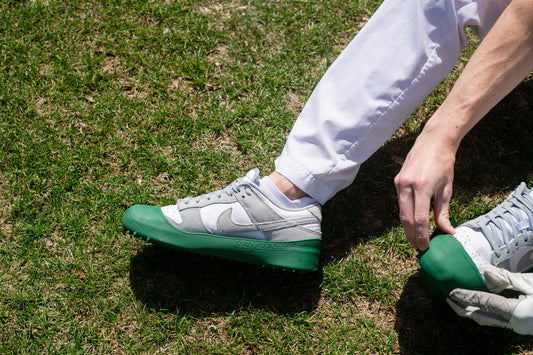 Golfer putting MyMullies over sneakers before teeing off